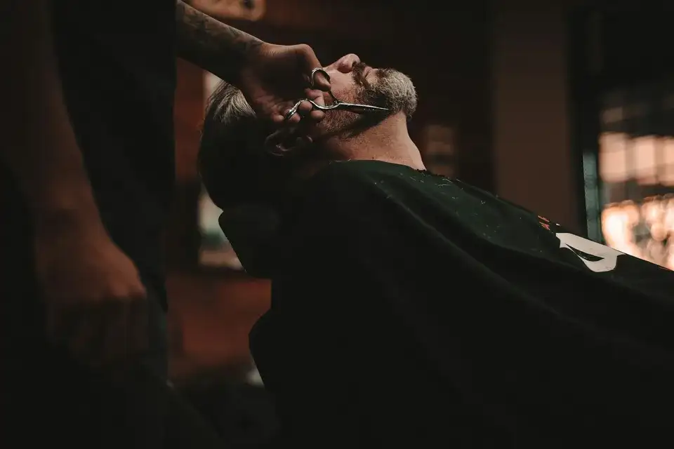 Rifinitura della barba con le forbici da barbiere